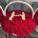 Ваше имя из белых роз на фоне красных роз в больших корзинах