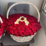 Ваше имя из белых роз на фоне красных роз в больших корзинах